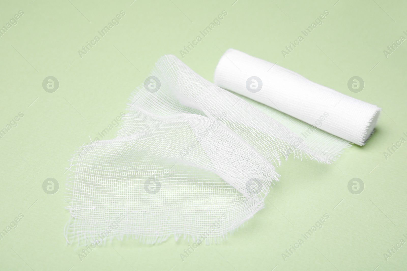 Photo of White medical bandage on light green background