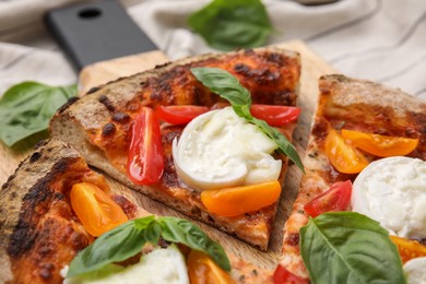 Photo of Delicious pizza with burrata cheese, tomatoes and basil on table, closeup