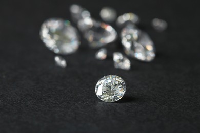 Photo of Beautiful shiny diamond on gray table, closeup. Space for text