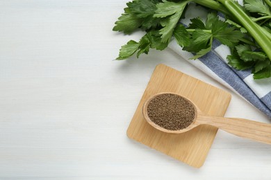 Spoon of celery seeds and fresh plant on white wooden table, flat lay. Space for text