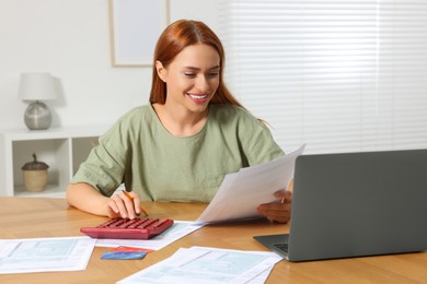 Woman calculating taxes at table in room