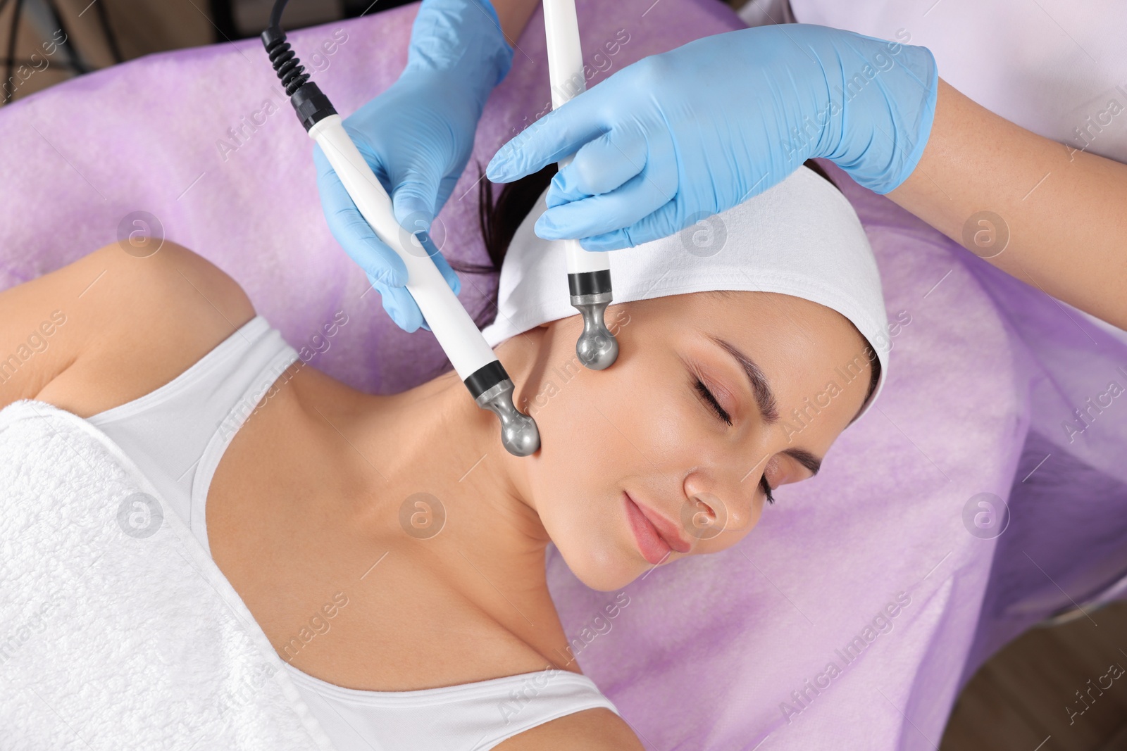 Photo of Young woman undergoing cosmetic procedure in beauty salon. Microcurrent therapy