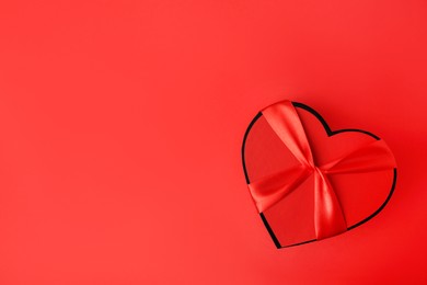 Beautiful heart shaped gift box on red background, top view. Space for text