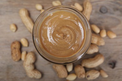 Tasty peanut nut paste in jar on table, top view