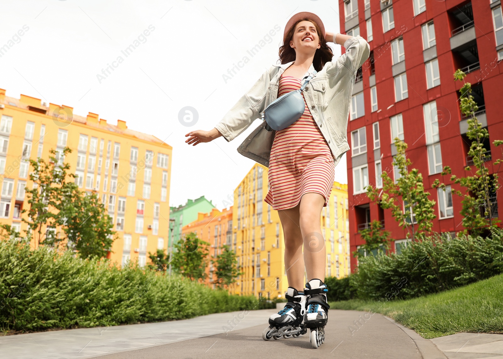 Photo of Beautiful young woman with roller skates having fun outdoors, space for text