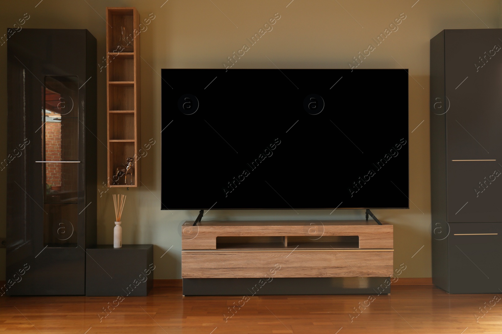 Photo of Modern TV set on table in room. Interior design