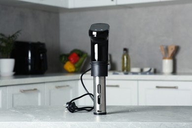 Photo of Thermal immersion circulator on table in kitchen. Sous vide cooking