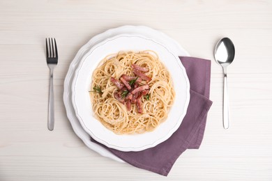 Photo of Delicious Carbonara pasta served on white wooden table, flat lay