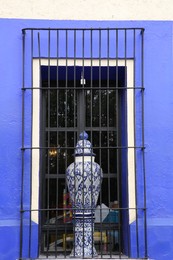 Photo of Blue building with beautiful window and steel grilles