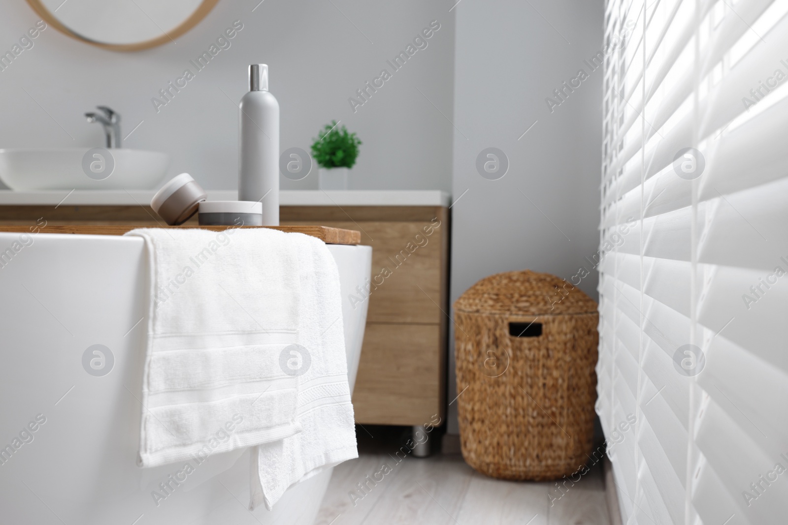 Photo of Fresh white towels on tub in bathroom. Space for text