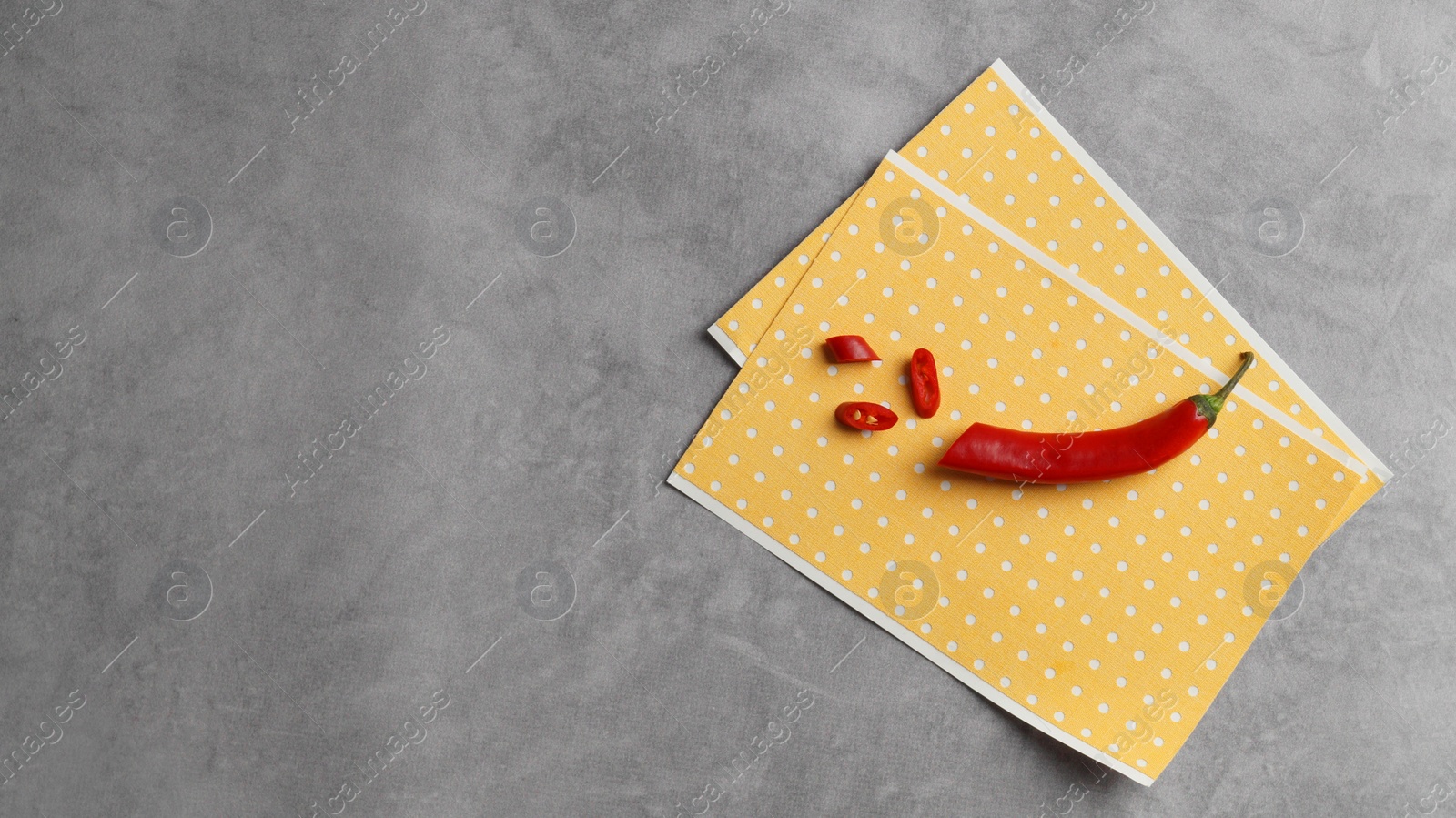 Photo of Pepper plasters and chili on grey textured background, top view. Space for text