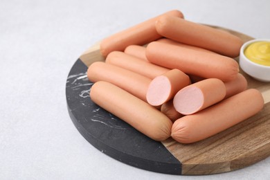 Photo of Delicious boiled sausages on light gray table, closeup