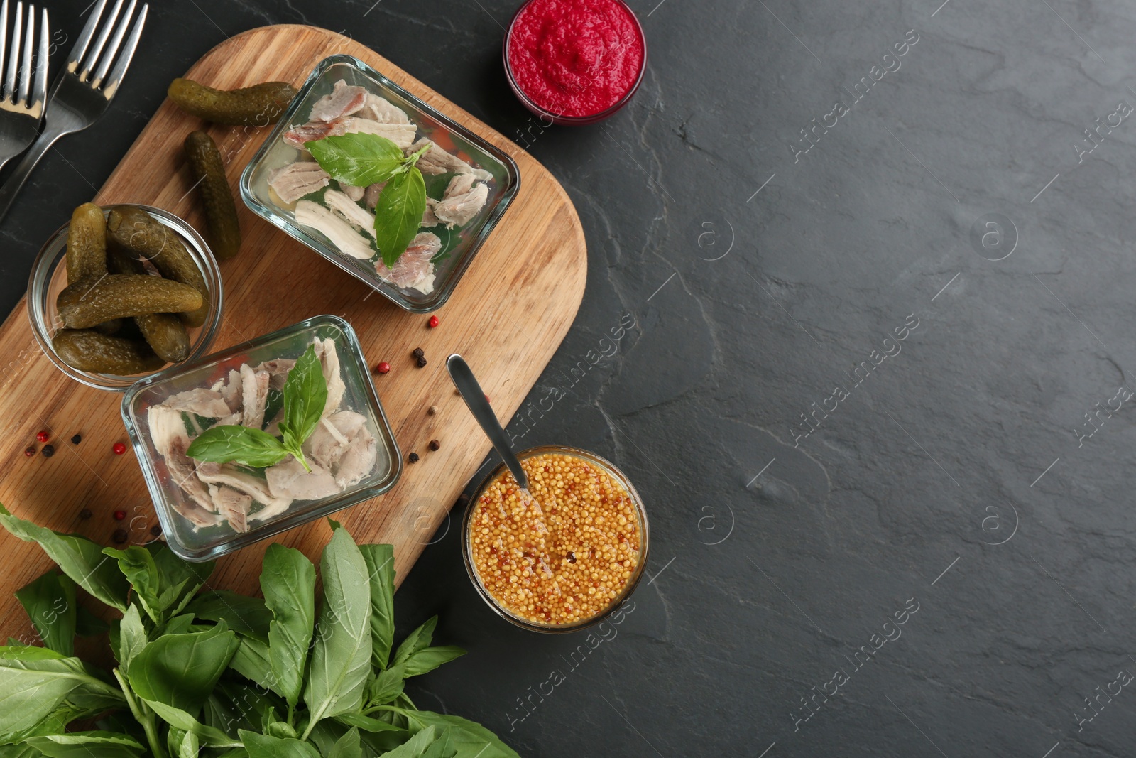 Photo of Delicious aspic with meat served on black slate table, flat lay. Space for text