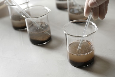 Photo of Scientist preparing soil extract at table, closeup. Laboratory analysis