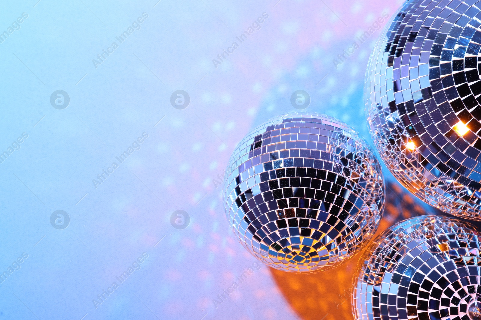 Photo of Bright shiny disco balls on color background. Space for text