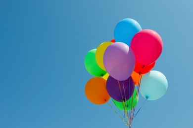 Bunch of colorful balloons against blue sky. Space for text