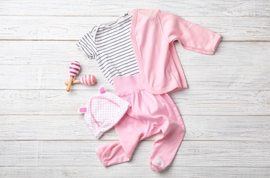 Photo of Flat lay composition with baby clothes and accessories on wooden background