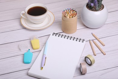 Photo of Open notebook, stationery and coffee on white wooden table. Planning concept