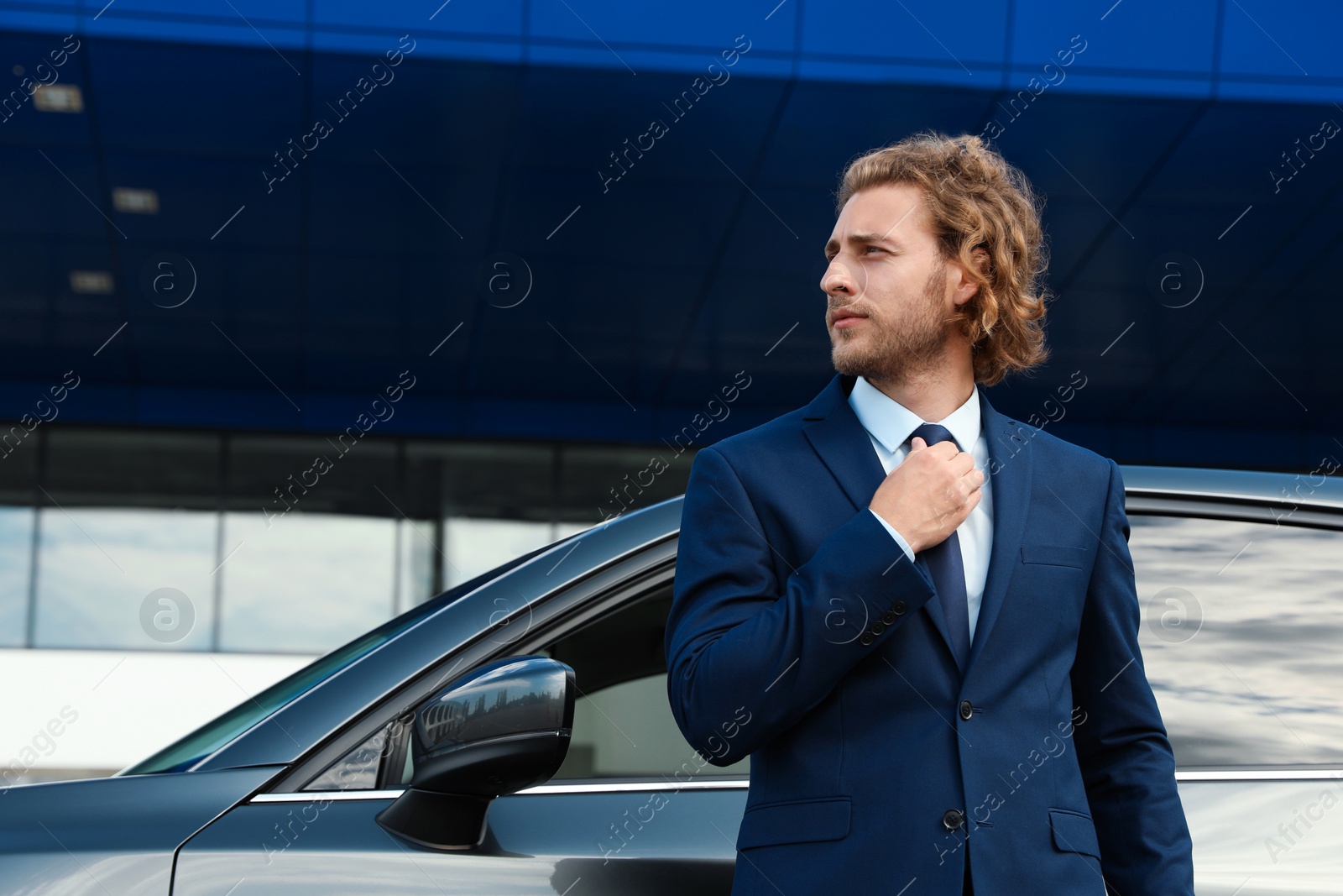 Photo of Attractive young man near luxury car outdoors