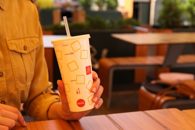 MYKOLAIV, UKRAINE - AUGUST 11, 2021: Woman with cold McDonald's drink outdoors, closeup. Space for text