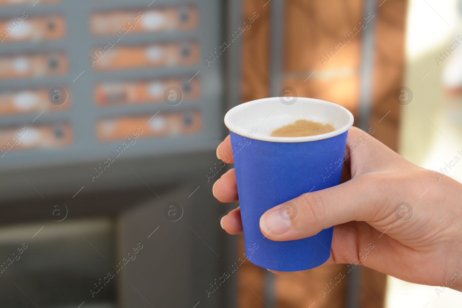 Photo of Woman holding paper cup with coffee near vending machine, closeup. Space for text