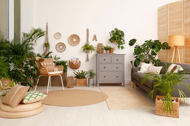 Living room interior with stylish furniture and green plants