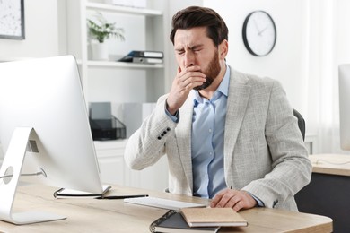 Photo of Sick man coughing at workplace in office. Cold symptoms