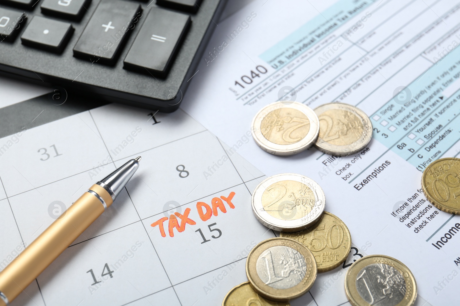 Photo of Calendar with date reminder about tax day, documents, coins, pen and calculator, closeup