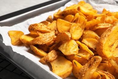 Photo of Sheet pan with delicious oven baked potatoes, closeup