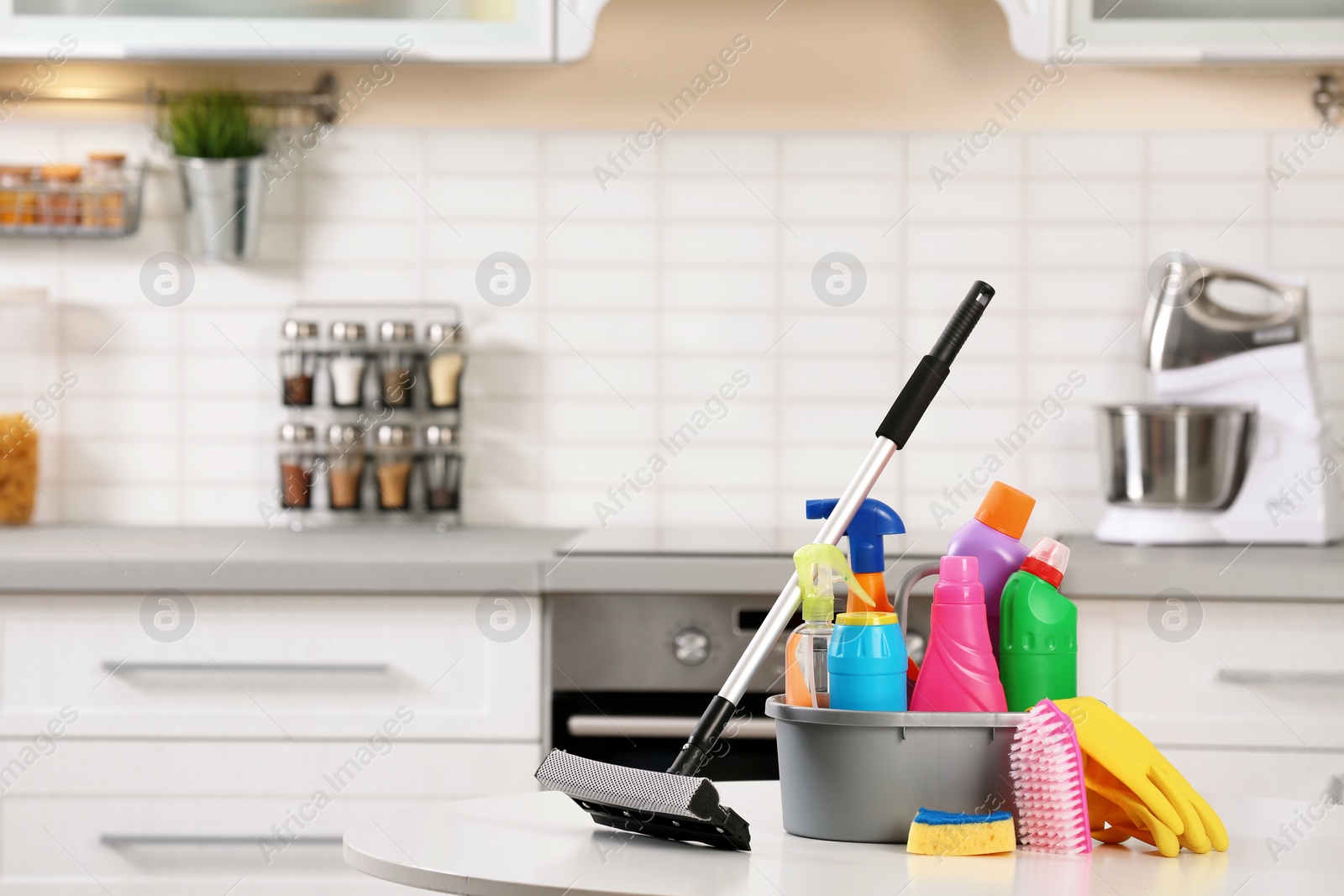 Photo of Set of cleaning supplies on table in kitchen. Space for text