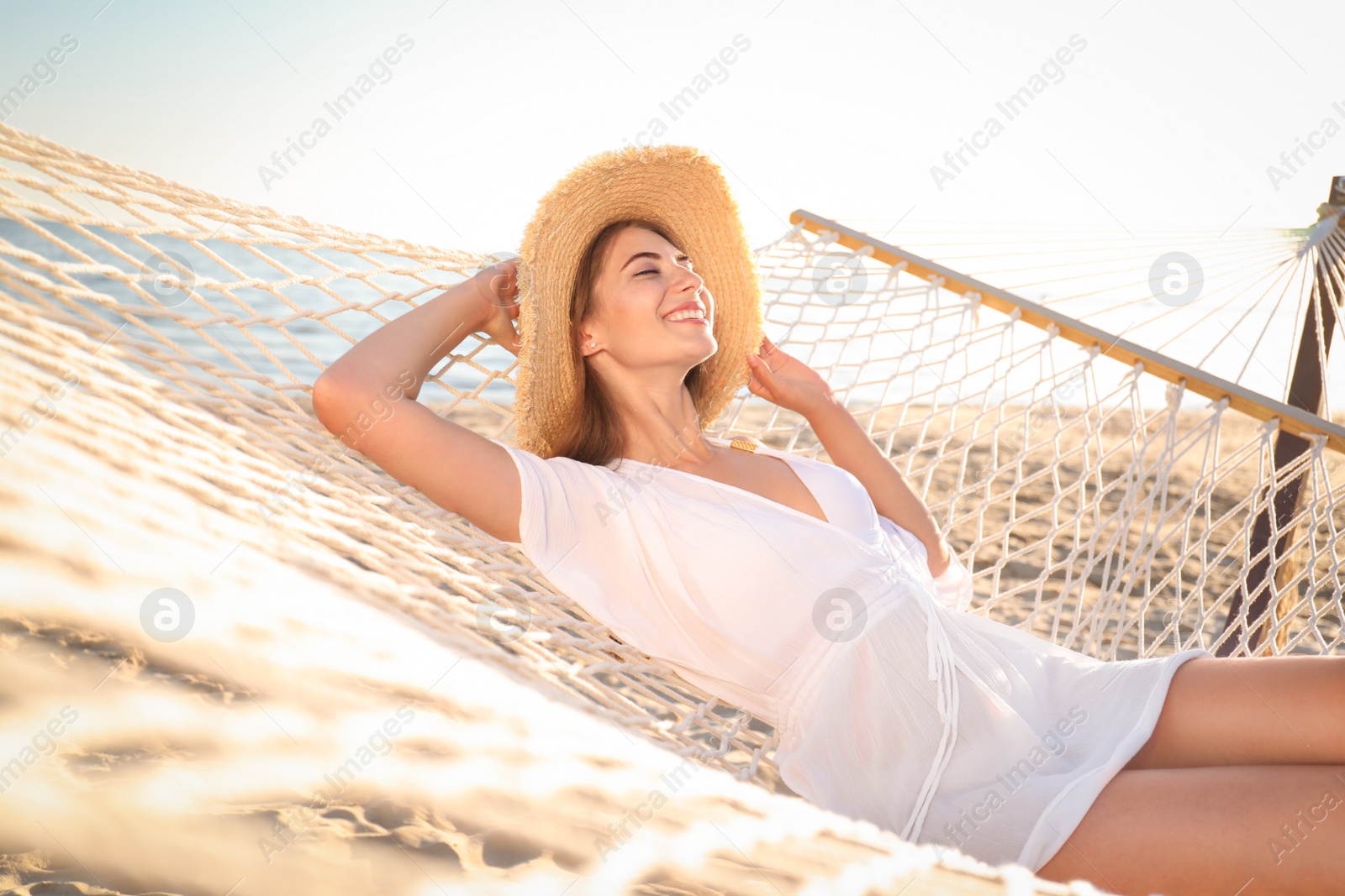 Photo of Young woman relaxing in hammock on beach