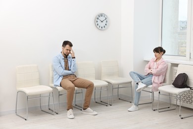 Man and woman waiting for appointment indoors