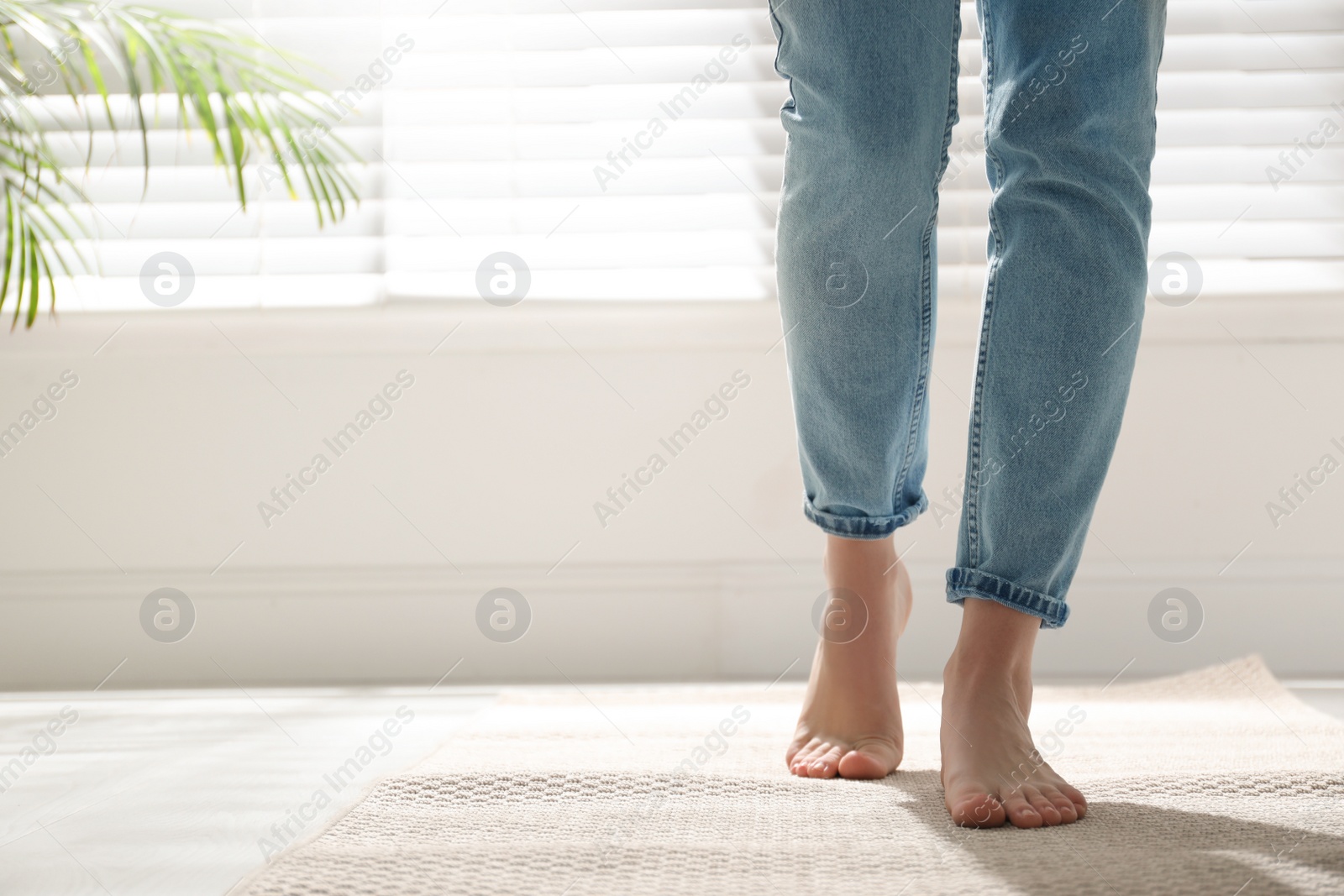 Photo of Woman standing on carpet at home, closeup. Space for text