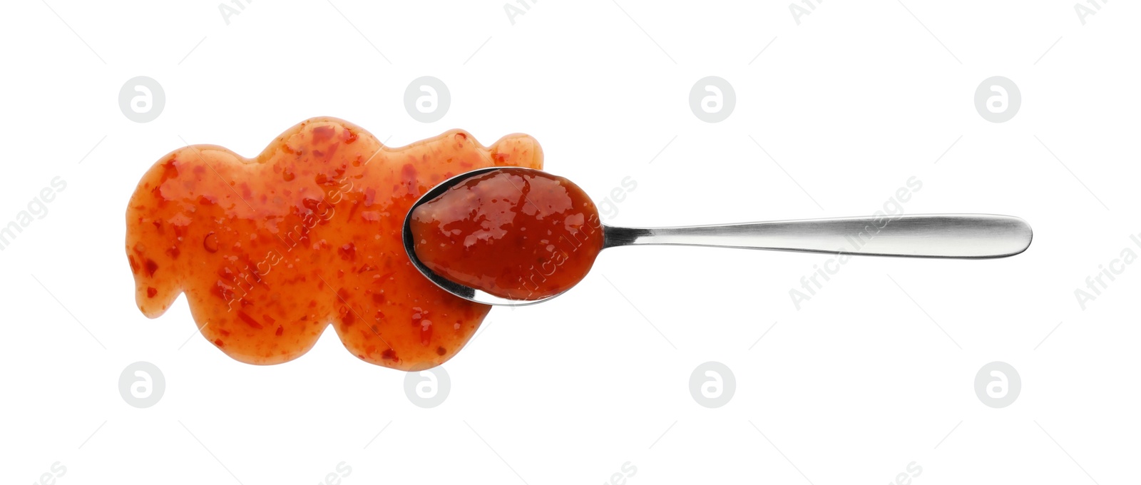 Photo of Tasty chili sauce and spoon isolated on white, top view
