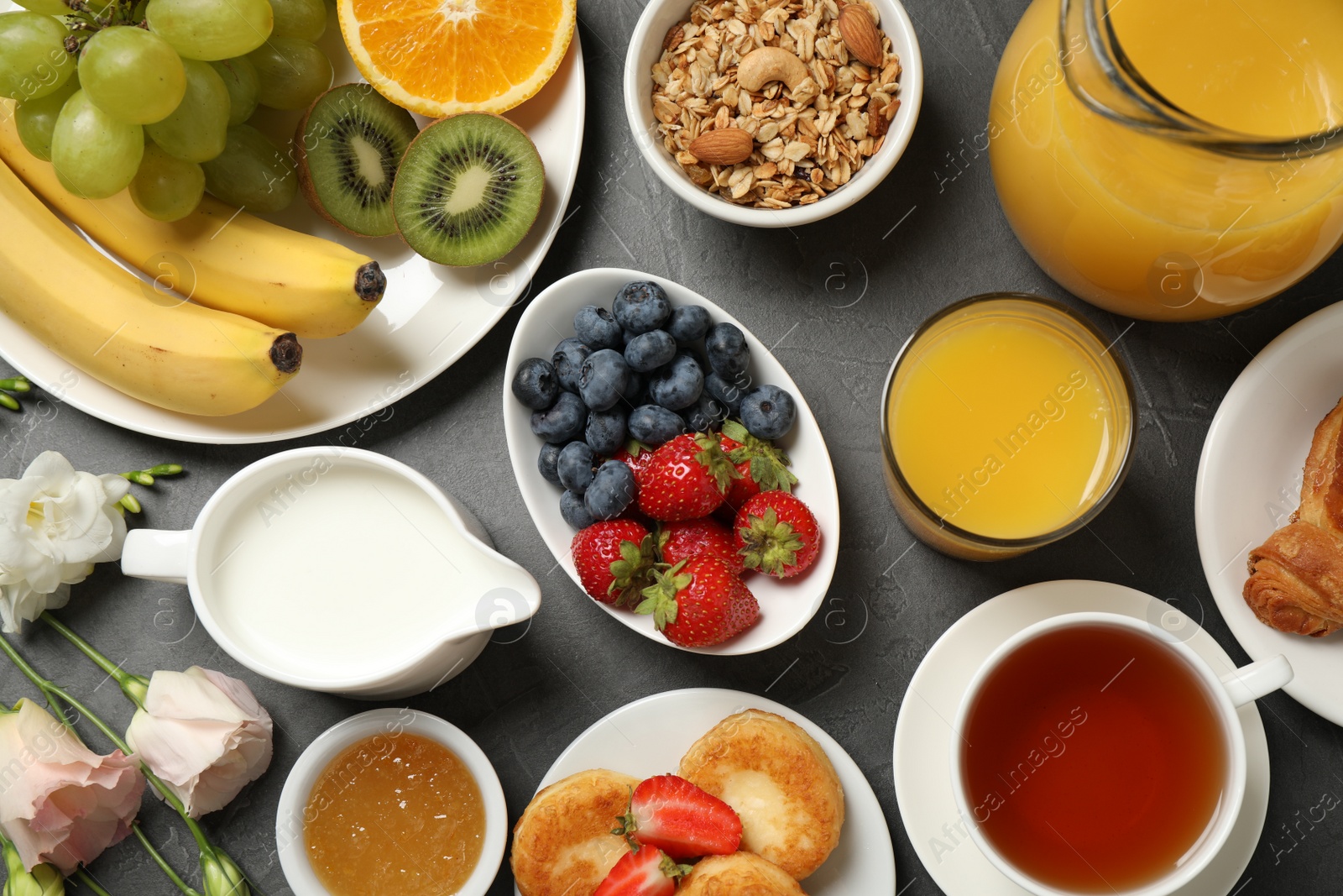 Photo of Buffet service. Tasty breakfast served on grey table, flat lay