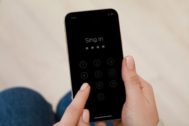 Photo of Woman unlocking smartphone with blocked screen indoors, closeup