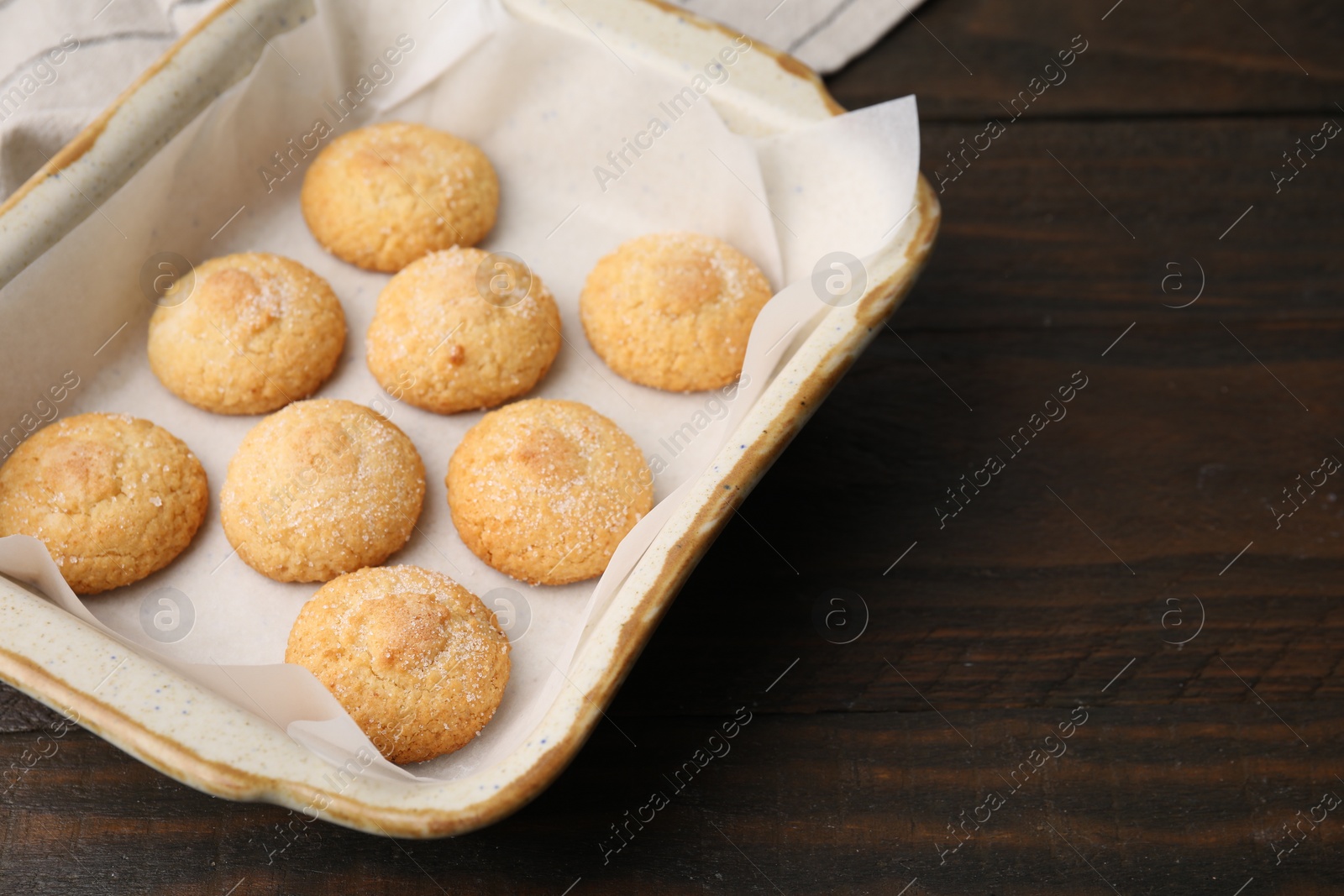 Photo of Tasty sweet sugar cookies in baking dish on wooden table, closeup. Space for text