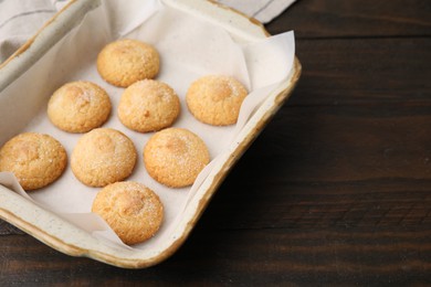 Photo of Tasty sweet sugar cookies in baking dish on wooden table, closeup. Space for text