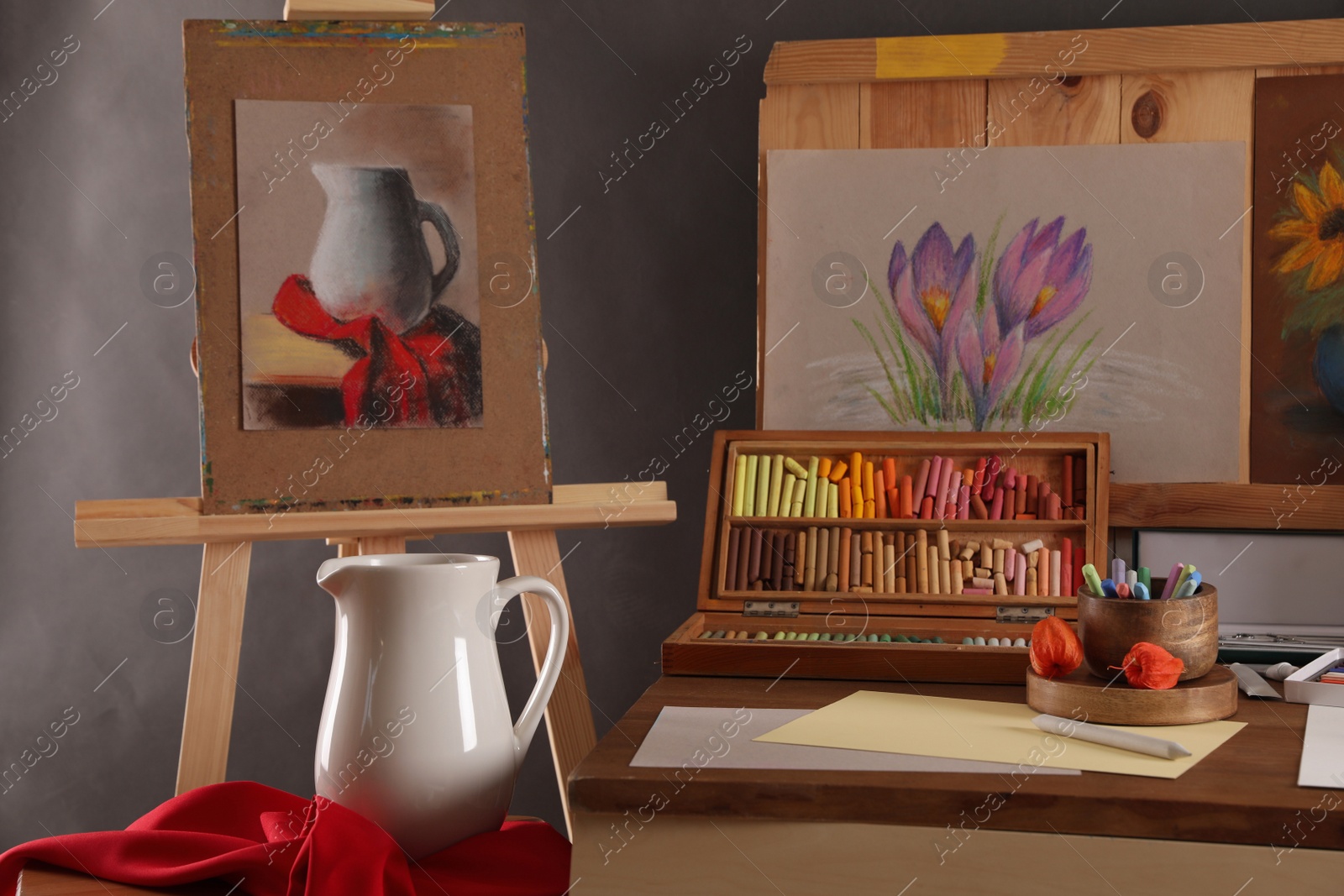 Photo of Artist's workplace with drawings, soft pastels and color pencils on table