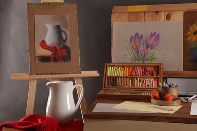 Photo of Artist's workplace with drawings, soft pastels and color pencils on table