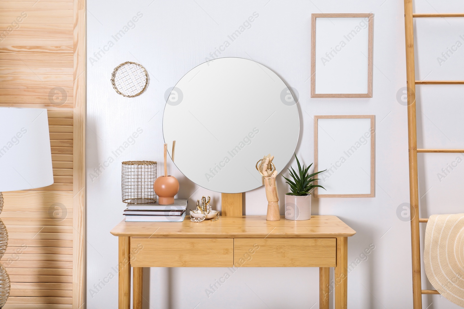 Photo of Modern wooden dressing table with mirror and decorative elements in room