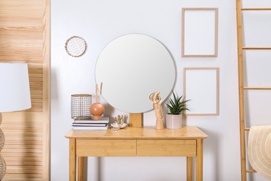 Photo of Modern wooden dressing table with mirror and decorative elements in room