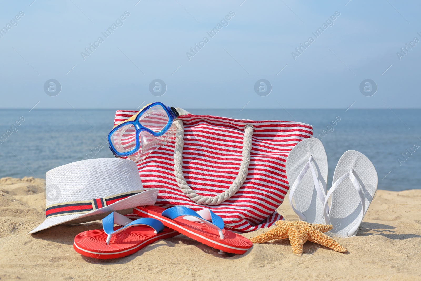 Photo of Set of different stylish beach accessories on sand