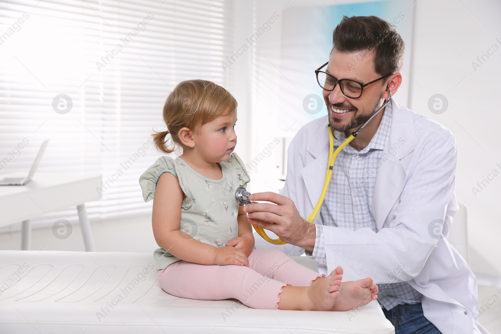 Photo of Pediatrician examining baby with stethoscope in clinic