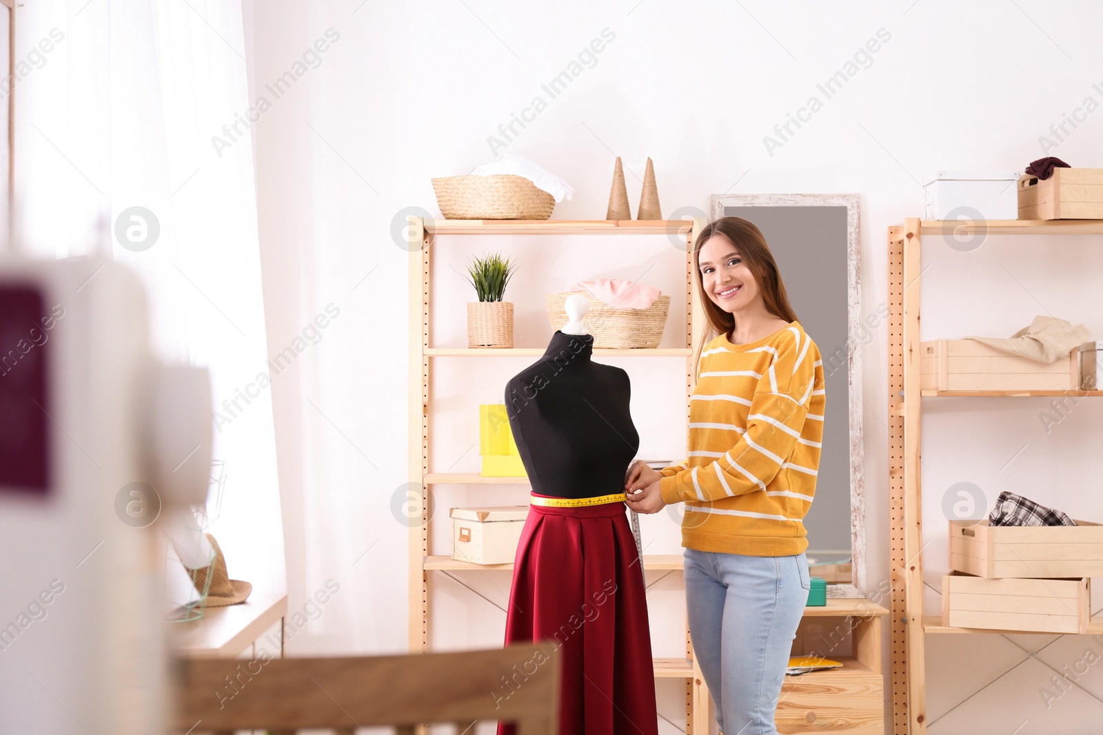 Photo of Fashion designer working with mannequin in studio. Creating new clothes