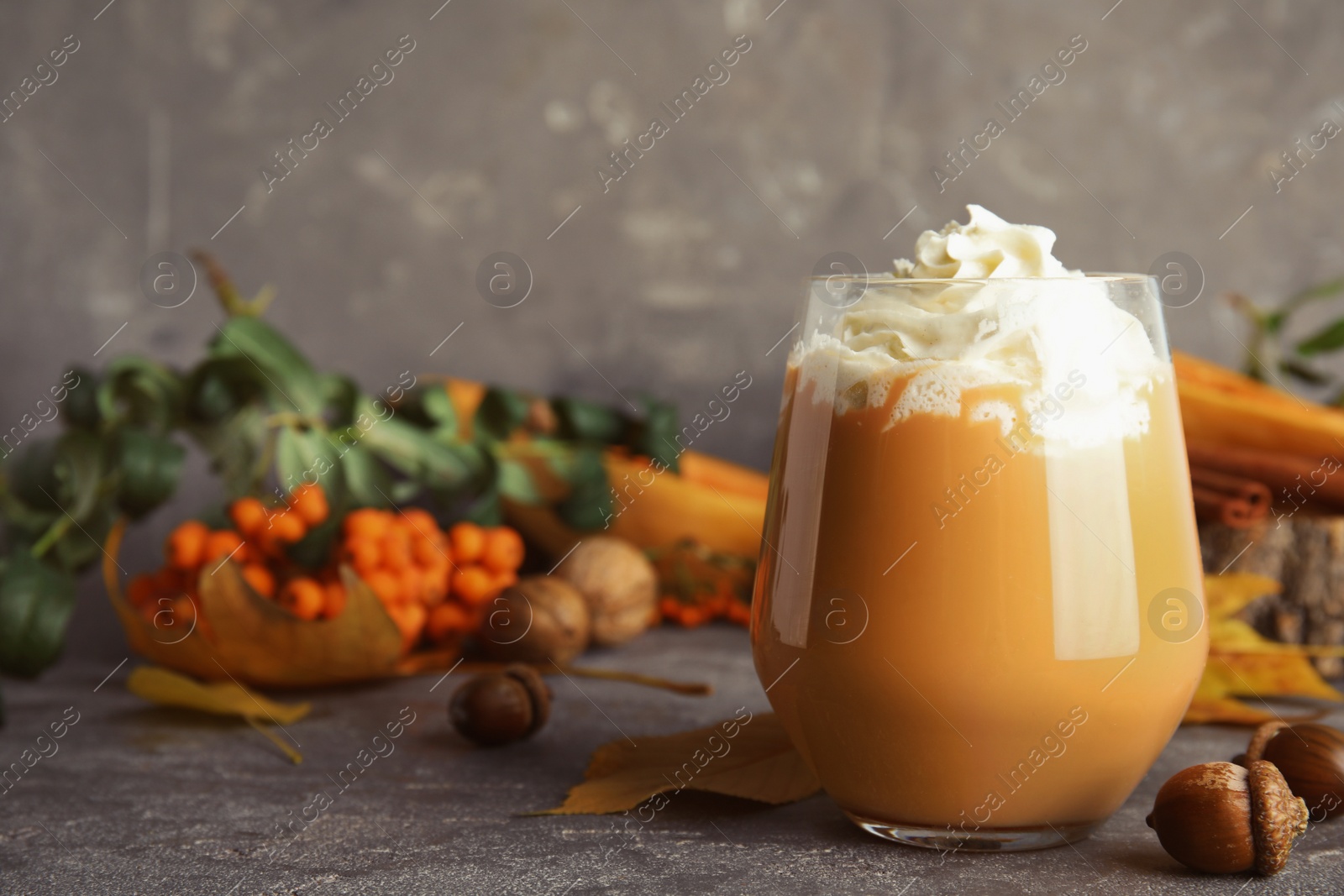 Photo of Composition with tasty pumpkin spice latte in glass on table. Space for text