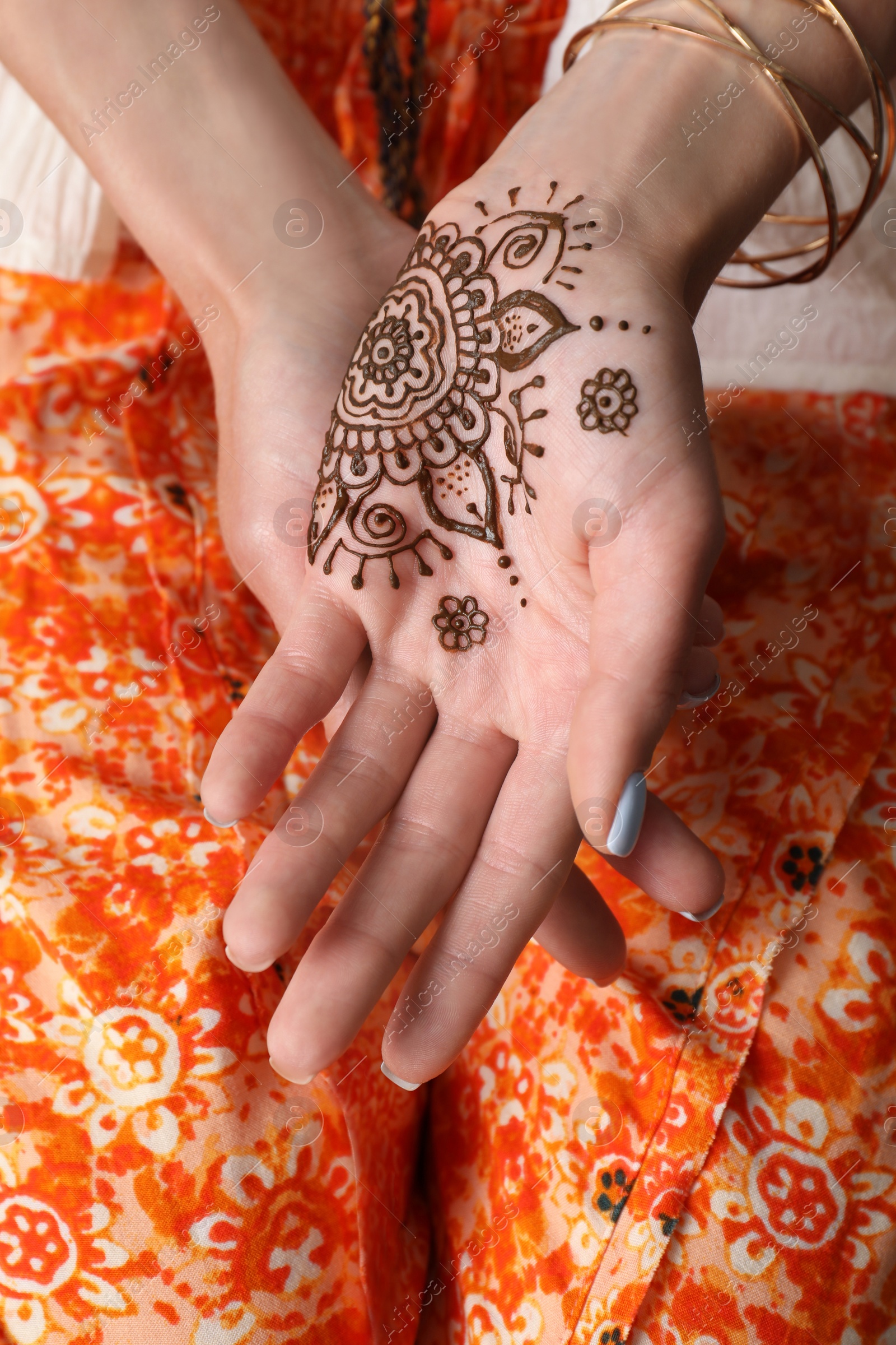 Photo of Woman with henna tattoo on palm, closeup. Traditional mehndi ornament