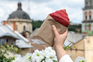 Photo of Woman with delicious croissant outdoors, closeup. Space for text