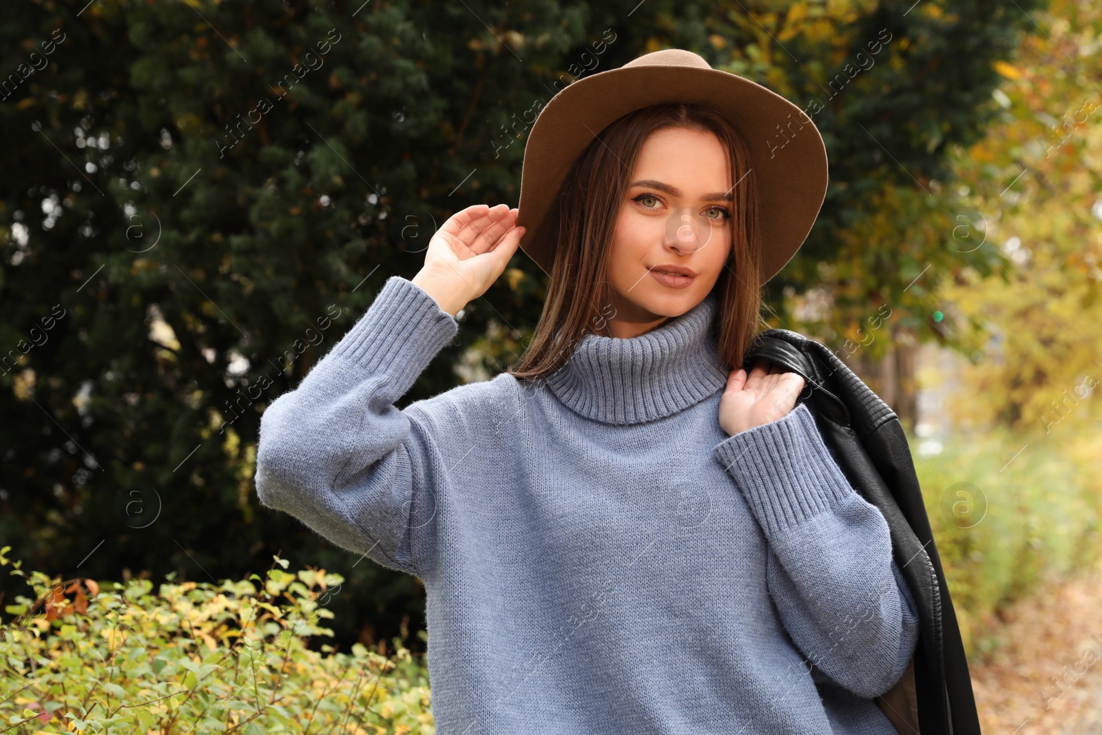 Photo of Beautiful young woman wearing stylish clothes in autumn park