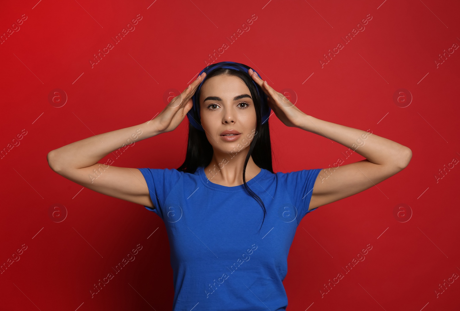 Photo of Young woman wearing stylish bandana on red background